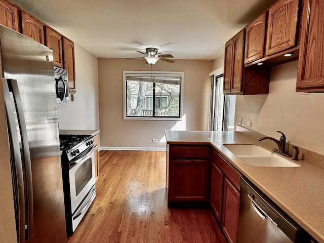 300 Pembridge Ln Unit D2, Schaumburg, IL 60193 - kitchen with appliances with stainless steel finishes, ceiling fan, wood finished floors, light countertops, and brown cabinets