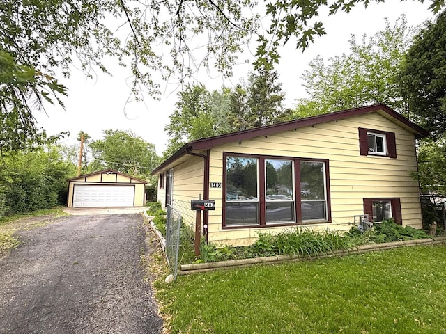 1403 Kings Rd, Carpentersville, IL 60110 - view of side of home featuring a garage, an outbuilding, and a lawn