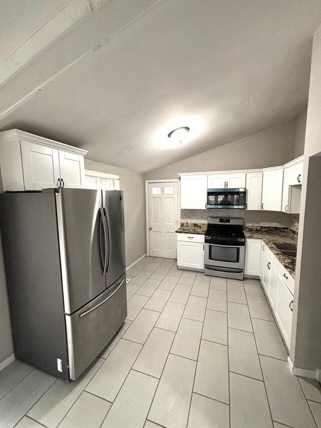 1403 Kings Rd, Carpentersville, IL 60110 - kitchen with stainless steel appliances, vaulted ceiling, dark countertops, white cabinets, and a sink