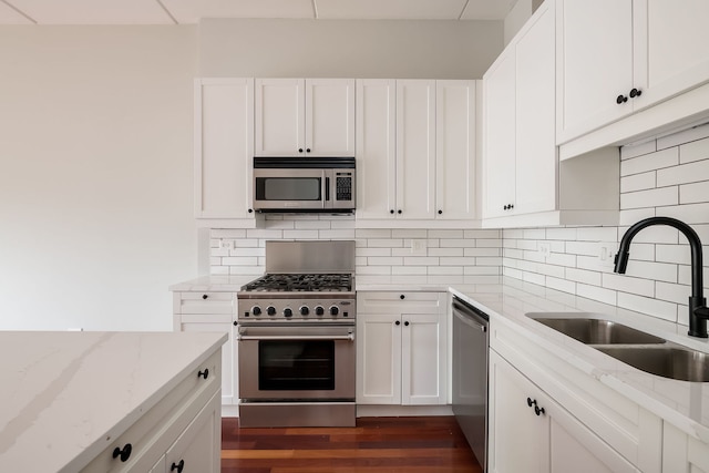 3125 W Fullerton Ave Unit 214, Chicago, IL 60647 - kitchen with appliances with stainless steel finishes, white cabinetry, light stone countertops, and decorative backsplash