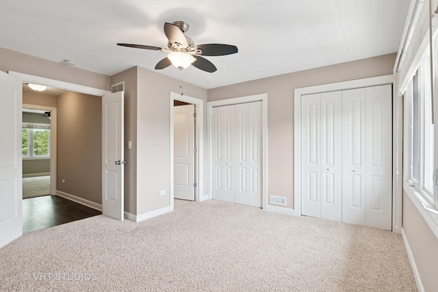 313 N Hale St, Wheaton, IL 60187 - unfurnished bedroom featuring dark carpet, two closets, and a ceiling fan