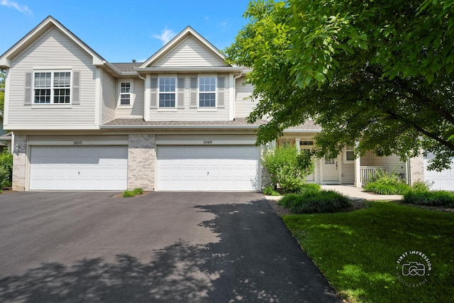 2049 Sunrise Cir, Aurora, IL 60503 - multi unit property featuring a garage, asphalt driveway, brick siding, a front lawn, and a shingled roof