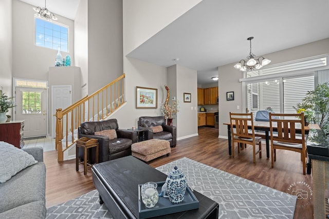 2049 Sunrise Cir, Aurora, IL 60503 - living room with a chandelier, stairway, wood finished floors, and a towering ceiling