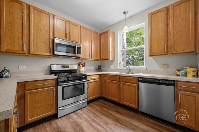 2049 Sunrise Cir, Aurora, IL 60503 - kitchen featuring appliances with stainless steel finishes, dark wood finished floors, light countertops, and hanging light fixtures