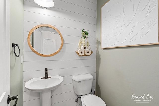 1405 Navajo Ct, Kankakee, IL 60901 - bathroom featuring toilet, a sink, and wooden walls
