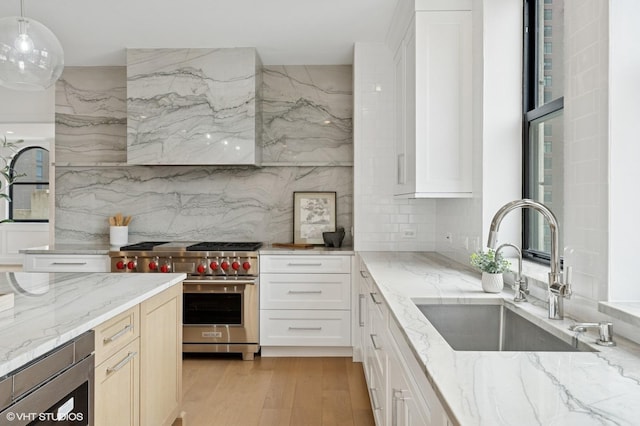 1155 N Dearborn St Unit 1301, Chicago, IL 60610 - kitchen featuring designer range, a sink, light stone counters, decorative backsplash, and light wood-style flooring