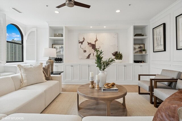 1155 N Dearborn St Unit 1301, Chicago, IL 60610 - living room featuring built in shelves, light wood-type flooring, crown molding, a ceiling fan, and a decorative wall