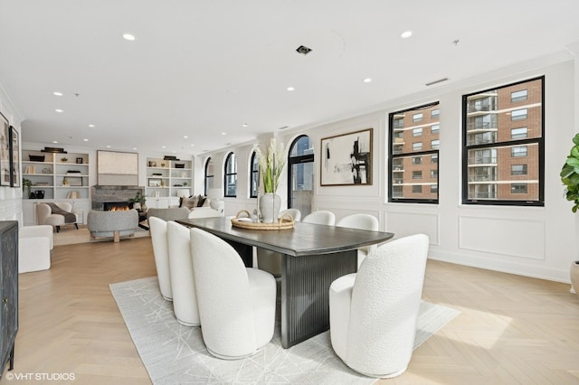 1155 N Dearborn St Unit 1301, Chicago, IL 60610 - dining room featuring recessed lighting, a lit fireplace, crown molding, and built in shelves