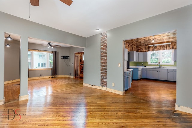 455 Sylvan Ave, Grand Ridge, IL 61325 - unfurnished living room with a ceiling fan, a sink, wood finished floors, and baseboards