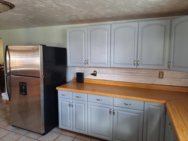 306 N Joy St, Tampico, IL 61283 - kitchen featuring freestanding refrigerator, light tile patterned flooring, and a textured ceiling