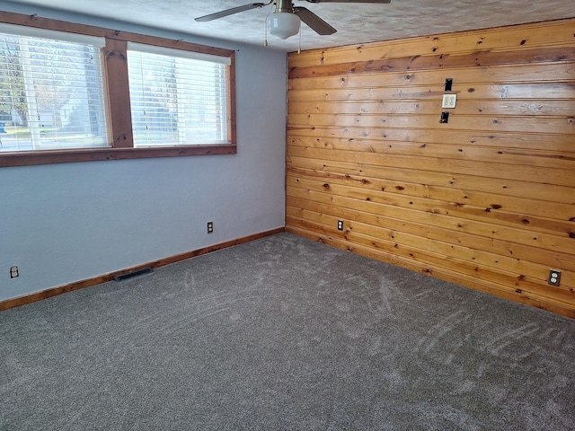 306 N Joy St, Tampico, IL 61283 - spare room with a ceiling fan, carpet floors, baseboards, and wooden walls