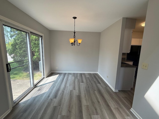 252 Kensington Ct, Gurnee, IL 60031 - unfurnished dining area featuring wood finished floors, a chandelier, and baseboards