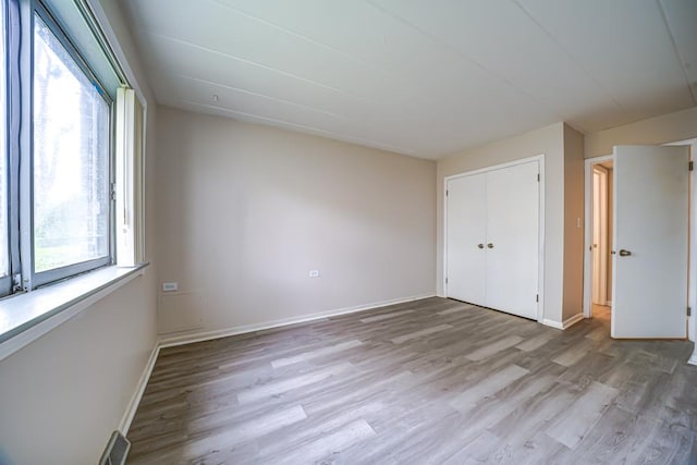 127 N Wolf Rd Unit 63A, Wheeling, IL 60090 - unfurnished bedroom featuring light wood-style floors, baseboards, and a closet