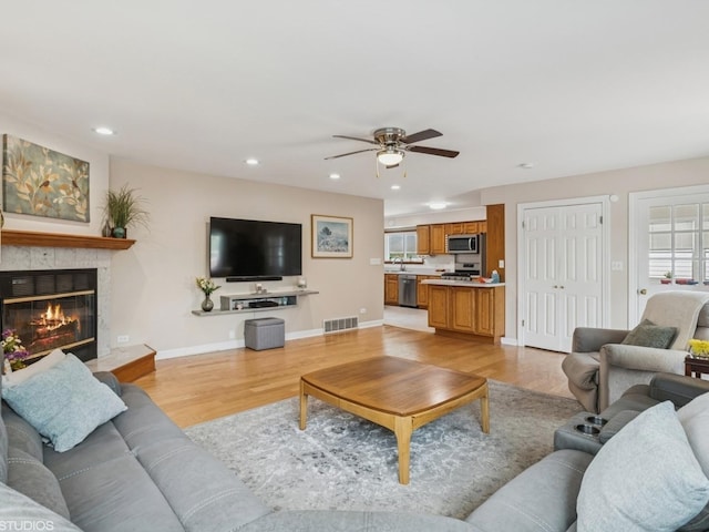 9907 Kedvale Ave, Skokie, IL 60076 - living room with light wood finished floors, ceiling fan, recessed lighting, and a glass covered fireplace