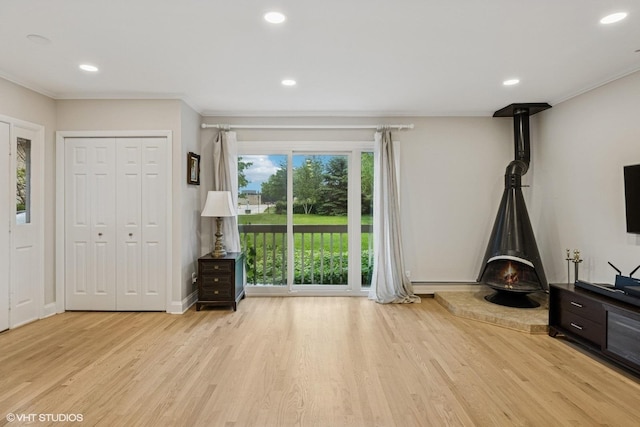 216 Eastern Ave, Barrington, IL 60010 - unfurnished living room with a wood stove, light wood-style flooring, recessed lighting, crown molding, and baseboards