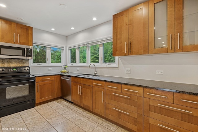 216 Eastern Ave, Barrington, IL 60010 - kitchen with appliances with stainless steel finishes, a sink, brown cabinetry, dark stone counters, and recessed lighting