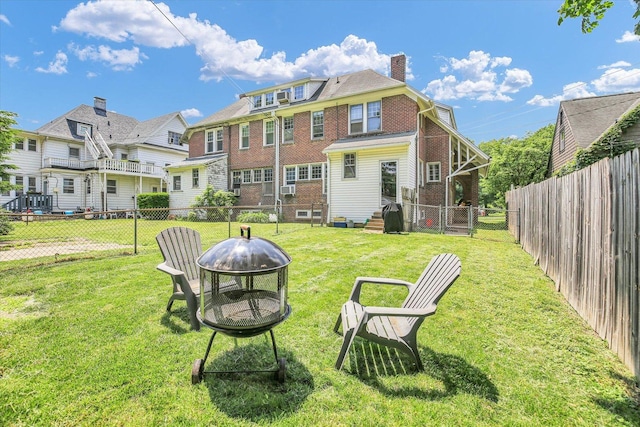 310 Davidson Dr, Champaign, IL 61821 - rear view of house with an outdoor fire pit, a fenced backyard, a chimney, brick siding, and a residential view
