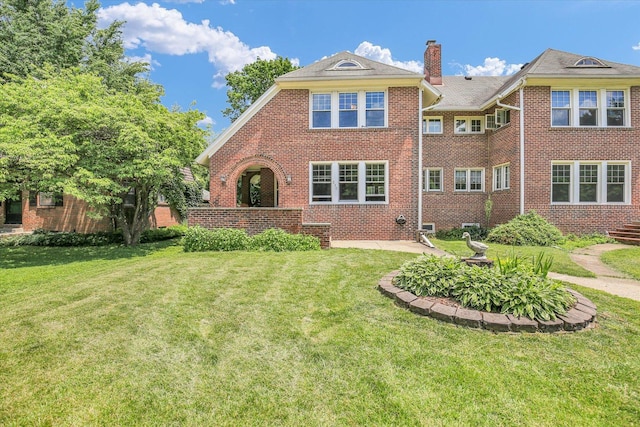 310 Davidson Dr, Champaign, IL 61821 - back of house with brick siding, a yard, and a chimney