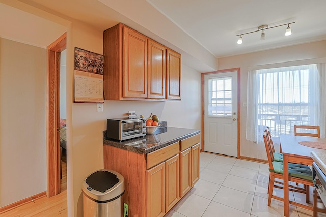 4925 N Harlem Ave Unit 3, Chicago, IL 60656 - kitchen featuring baseboards, light tile patterned flooring, and dark stone countertops