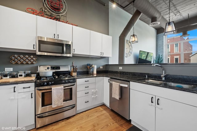 2750 N Wayne Ave Unit G, Chicago, IL 60614 - kitchen with stainless steel appliances, light wood finished floors, white cabinets, dark stone counters, and a sink