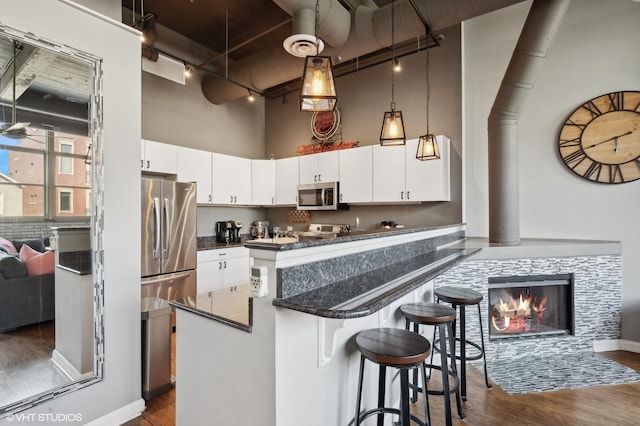 2750 N Wayne Ave Unit G, Chicago, IL 60614 - kitchen with stainless steel appliances, rail lighting, dark wood-type flooring, a towering ceiling, and a kitchen bar