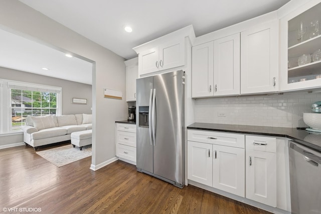 710 Western Ave, Glen Ellyn, IL 60137 - kitchen with appliances with stainless steel finishes, dark countertops, dark wood-type flooring, decorative backsplash, and glass insert cabinets