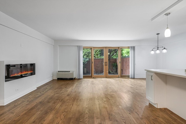 1115 S Plymouth Ct Unit 102, Chicago, IL 60605 - unfurnished living room featuring wood finished floors, a glass covered fireplace, baseboards, and an AC wall unit