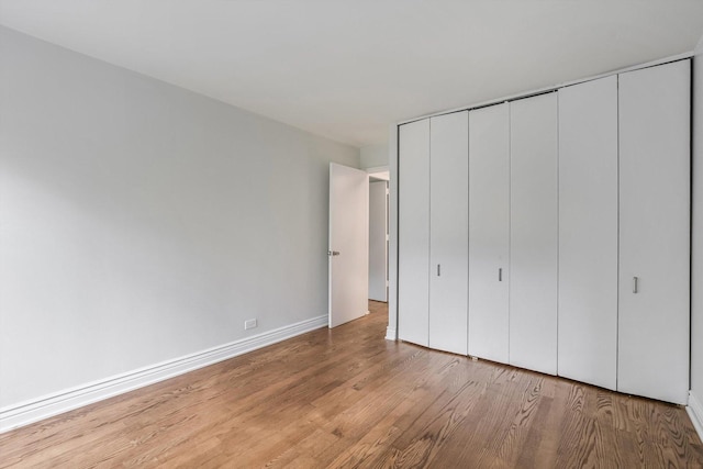 1115 S Plymouth Ct Unit 102, Chicago, IL 60605 - unfurnished bedroom featuring light wood-style flooring, a closet, and baseboards