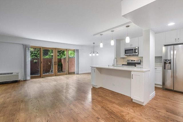 1115 S Plymouth Ct Unit 102, Chicago, IL 60605 - kitchen featuring stainless steel appliances, light wood-style floors, light countertops, a sink, and white cabinetry
