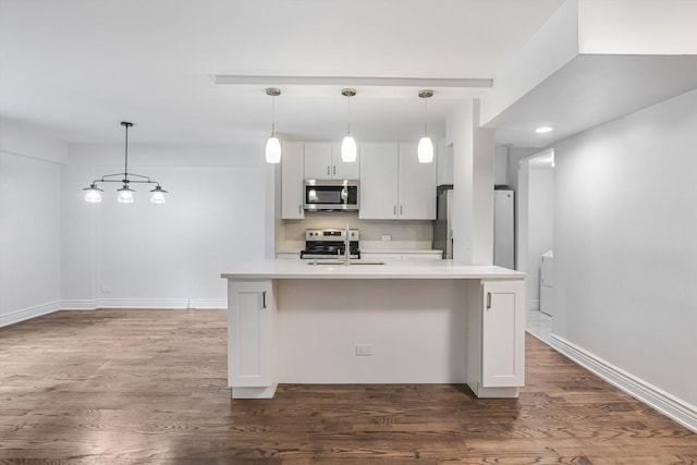 1115 S Plymouth Ct Unit 102, Chicago, IL 60605 - kitchen featuring appliances with stainless steel finishes, light countertops, a sink, white cabinetry, and dark wood-type flooring