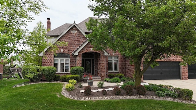 10880 Swallow Tail Ln, Frankfort, IL 60423 - english style home featuring brick siding, driveway, a front yard, a chimney, and a shingled roof