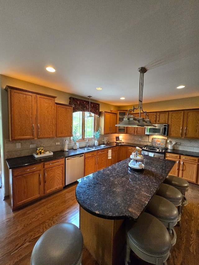 10880 Swallow Tail Ln, Frankfort, IL 60423 - kitchen with stainless steel appliances, a sink, brown cabinets, tasteful backsplash, and hanging light fixtures