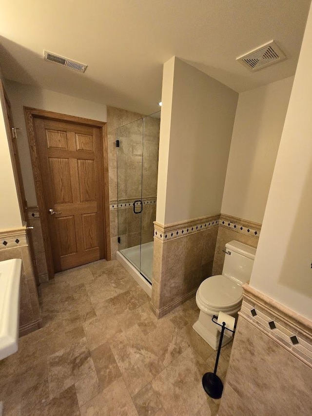 10880 Swallow Tail Ln, Frankfort, IL 60423 - bathroom with a stall shower, tile walls, toilet, and wainscoting