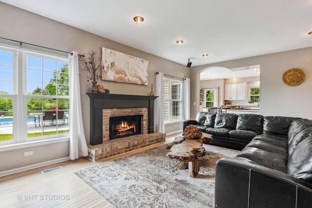 900 Legacy Rdg, Algonquin, IL 60102 - living area featuring light wood finished floors, a brick fireplace, and arched walkways