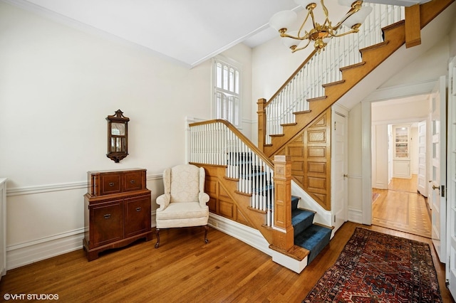 739 Forest Ave, Evanston, IL 60202 - staircase featuring a chandelier, wood finished floors, and baseboards