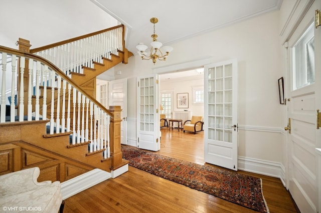 739 Forest Ave, Evanston, IL 60202 - foyer featuring wood finished floors, stairs, a chandelier, crown molding, and french doors