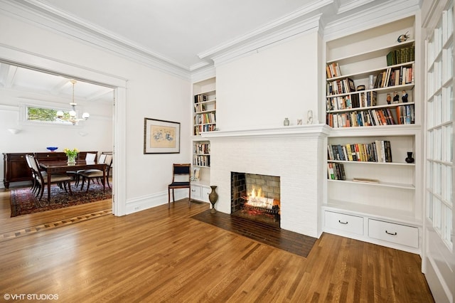 739 Forest Ave, Evanston, IL 60202 - living area featuring wood finished floors, built in shelves, crown molding, a fireplace, and baseboards