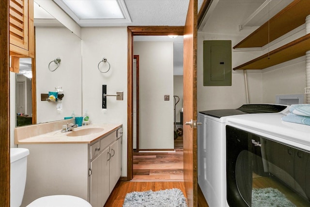1803 Oliver Dr Unit 3, Urbana, IL 61802 - bathroom with electric panel, washing machine and clothes dryer, vanity, wood finished floors, and toilet