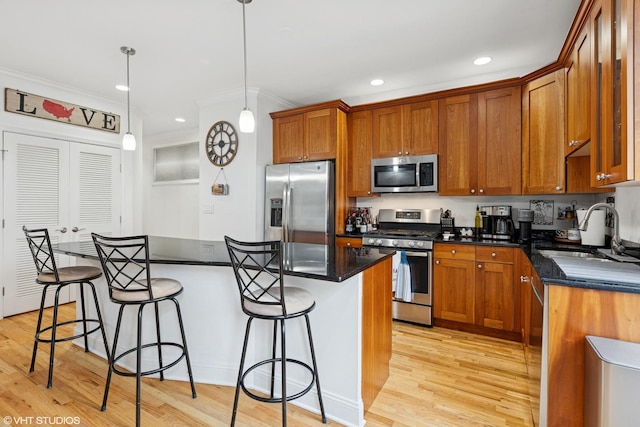 3717 N Wilton Ave Unit 1, Chicago, IL 60613 - kitchen featuring stainless steel appliances, a sink, a breakfast bar, light wood-style floors, and recessed lighting