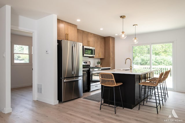 9058 Caddy Ct, Orland Park, IL 60462 - kitchen with stainless steel appliances, light wood-type flooring, a kitchen breakfast bar, recessed lighting, and light countertops