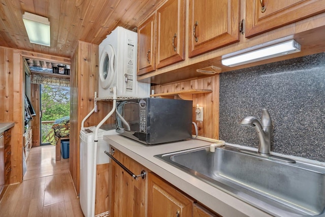 1 Dinosaur Rd, Wilmington, IL 60481 - kitchen with estacked washer and dryer, black microwave, a sink, wooden ceiling, and brown cabinets