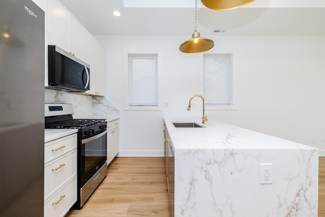 6048 S Eberhart Ave, Chicago, IL 60637 - kitchen featuring appliances with stainless steel finishes, a sink, a peninsula, light wood finished floors, and white cabinetry
