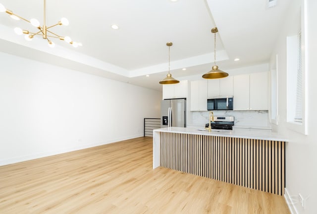 6048 S Eberhart Ave, Chicago, IL 60637 - kitchen featuring appliances with stainless steel finishes, a tray ceiling, light wood-style flooring, backsplash, and recessed lighting