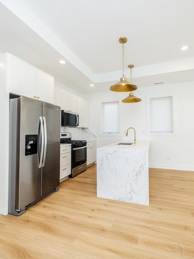 6048 S Eberhart Ave, Chicago, IL 60637 - kitchen featuring appliances with stainless steel finishes, light wood finished floors, white cabinets, a sink, and recessed lighting