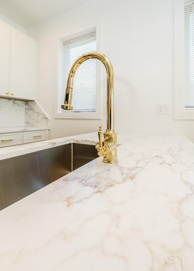 6048 S Eberhart Ave, Chicago, IL 60637 - kitchen view of white cabinetry, light stone countertops, tasteful backsplash, and a sink