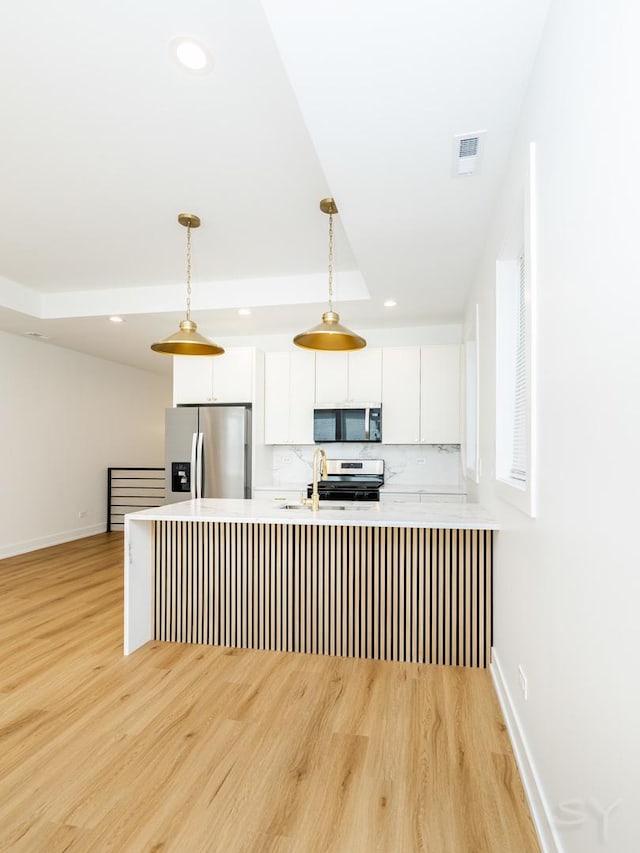6048 S Eberhart Ave, Chicago, IL 60637 - kitchen featuring appliances with stainless steel finishes, light wood-style flooring, white cabinets, light countertops, and decorative light fixtures