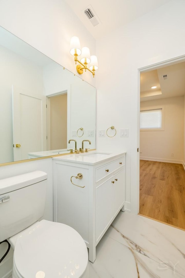 6048 S Eberhart Ave, Chicago, IL 60637 - bathroom featuring toilet, vanity, a chandelier, wood finished floors, and baseboards