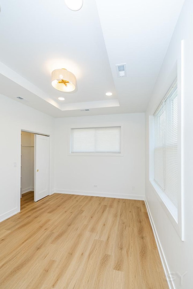 6048 S Eberhart Ave, Chicago, IL 60637 - unfurnished bedroom featuring a closet, light wood finished floors, a tray ceiling, baseboards, and recessed lighting
