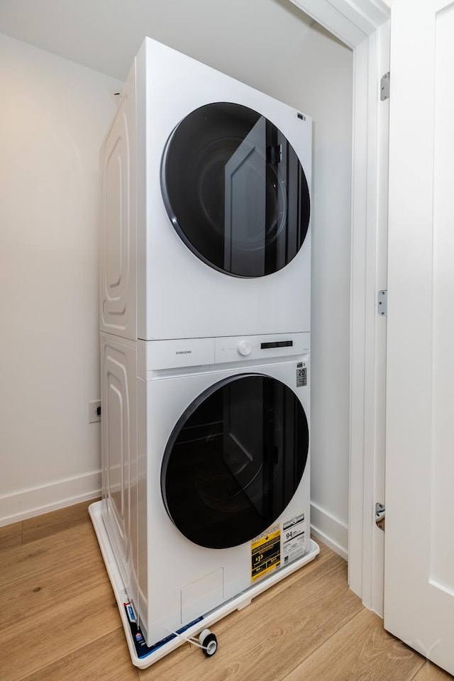 6048 S Eberhart Ave, Chicago, IL 60637 - laundry room featuring stacked washer / drying machine, light wood finished floors, and baseboards