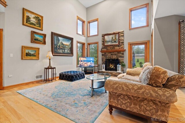 13851 S Janas Pkwy, Homer Glen, IL 60491 - living room featuring wood finished floors, a fireplace, a towering ceiling, and baseboards